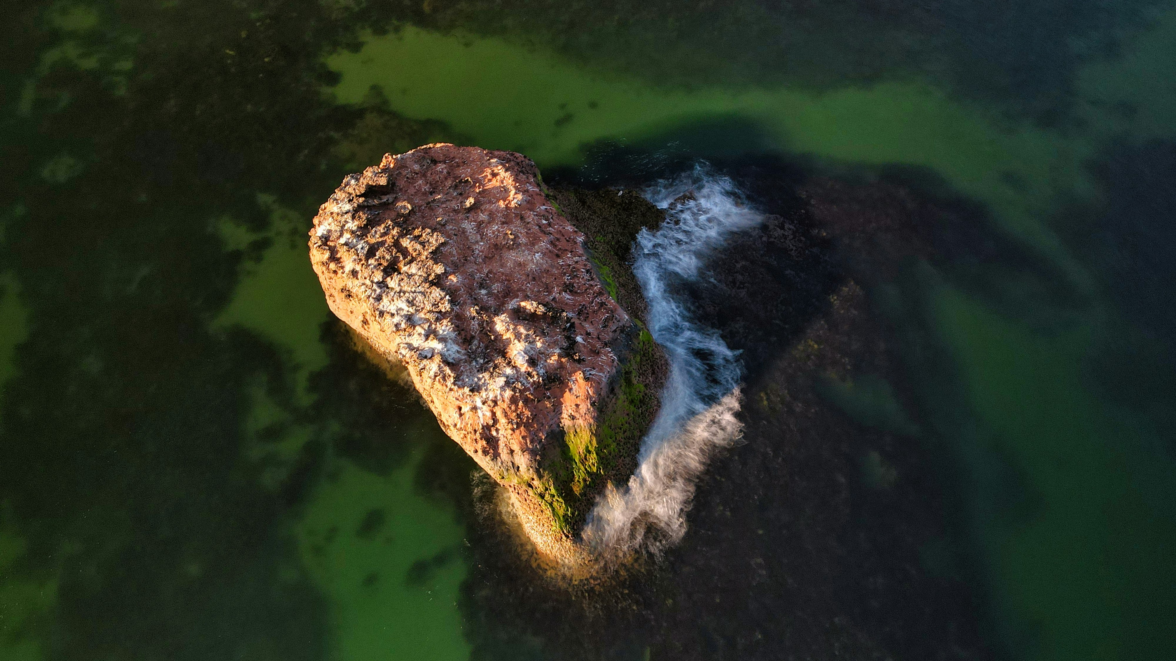 brown rock formation on water